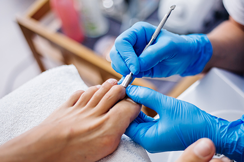 4.pedicure-process-home-salon-pedicure-foot-care-treatment-nail-process-professional-pedicures-master-blue-gloves-make-pedicure